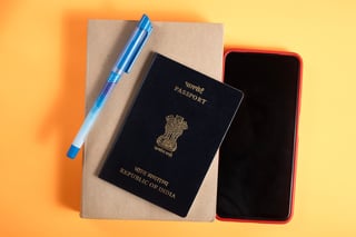 Close up of Indian passport, pen, notebook and phone 