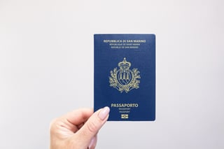 Gros plan d'un passeport de Saint-Marin tenu à la main sur un fond blanc uni
