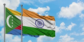 Comoros and india flags waving together in the wind on blue cloudy sky two country relationshi