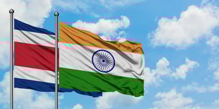 Drapeaux du Costa Rica et de l'Inde flottant ensemble dans le vent sous un ciel bleu nuageux