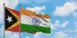 india and east timor flag waving in the wind against white cloudy blue sky
