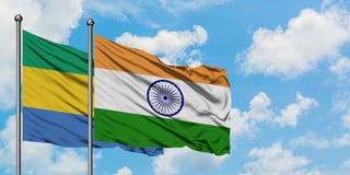 Gabon and india flag waving in the wind against white cloudy blue sky together diplomacy