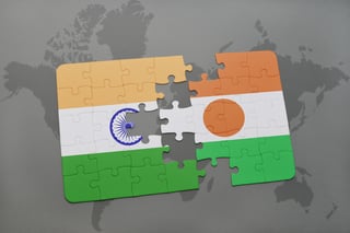 Puzzle with the National Flag of India and Niger on a World Map Background