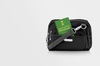 Passeport saoudien dans la poche d'un sac de voyage noir avec espace de copie sur fond isolé