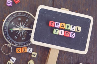 Vacation And Holiday Concept With Travel Tips Word Block On Wooden Signage And Compass Faded