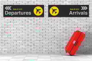 vacation concept red polycarbonate suitcase moving from airport with departures and arrivals