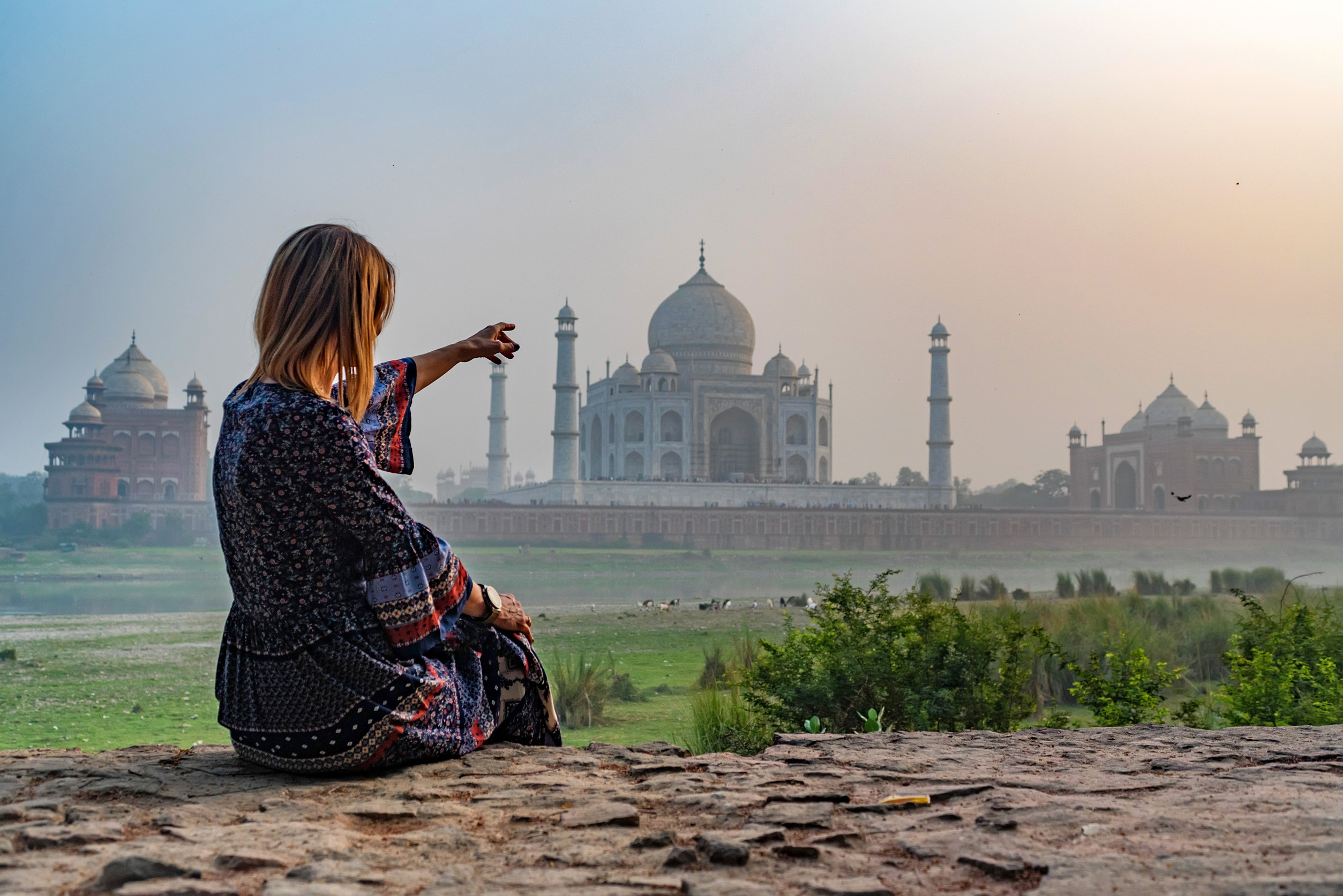 Schönes Mädchen zeigt auf das Taj Mahal (Konzept)