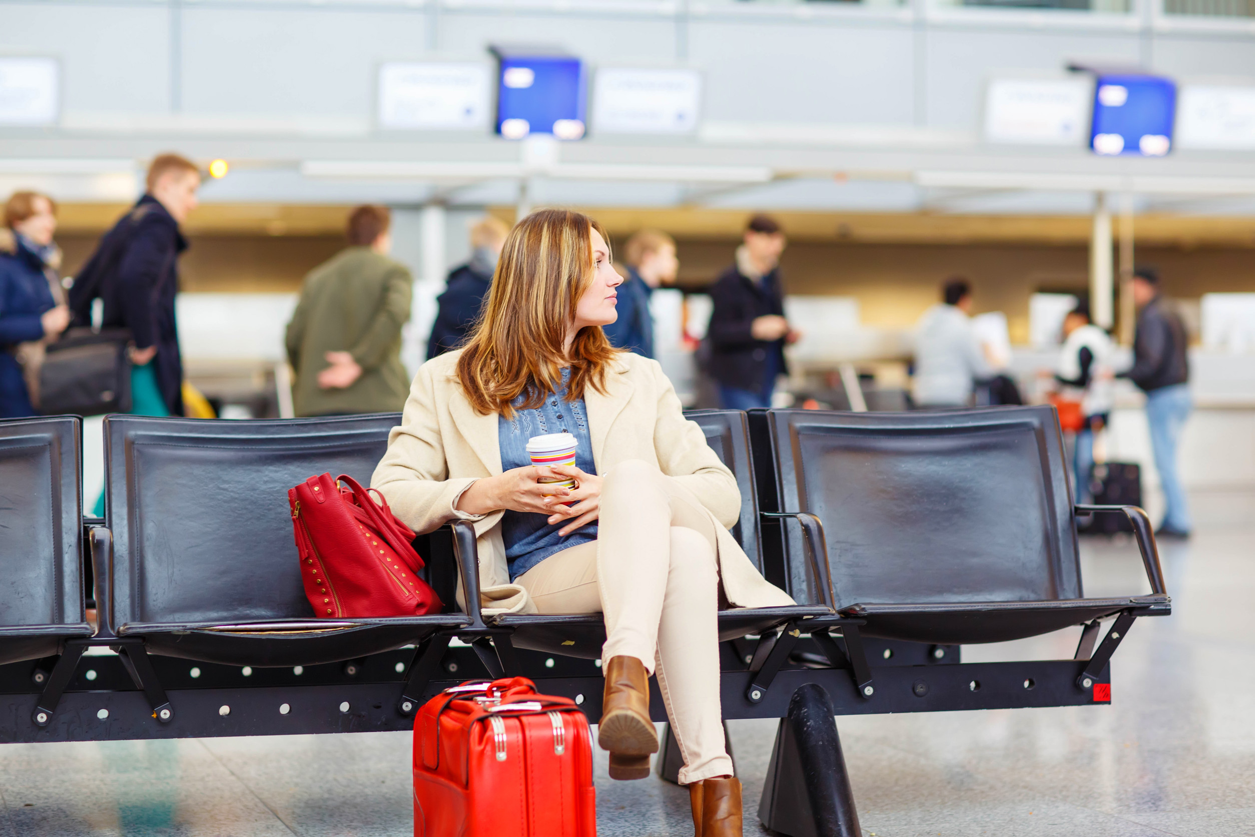 Geschäftsfrau am internationalen Flughafen sitzt und trinkt Kaffee im Terminal