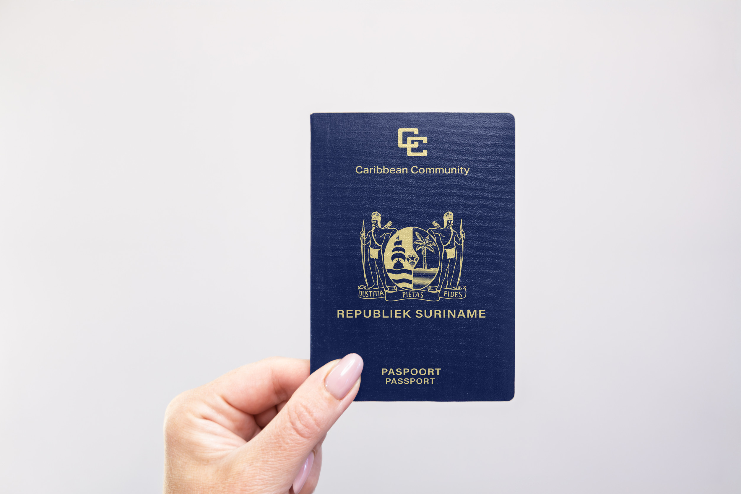 Nahaufnahme eines Suriname-Passes, der in der Hand vor weißem Hintergrund gehalten wird