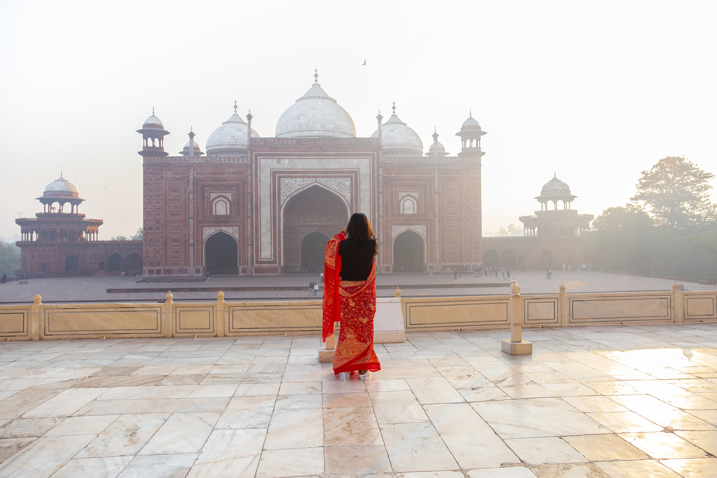 Indische Frau im Sari macht morgens ein Foto vom Taj Mahal