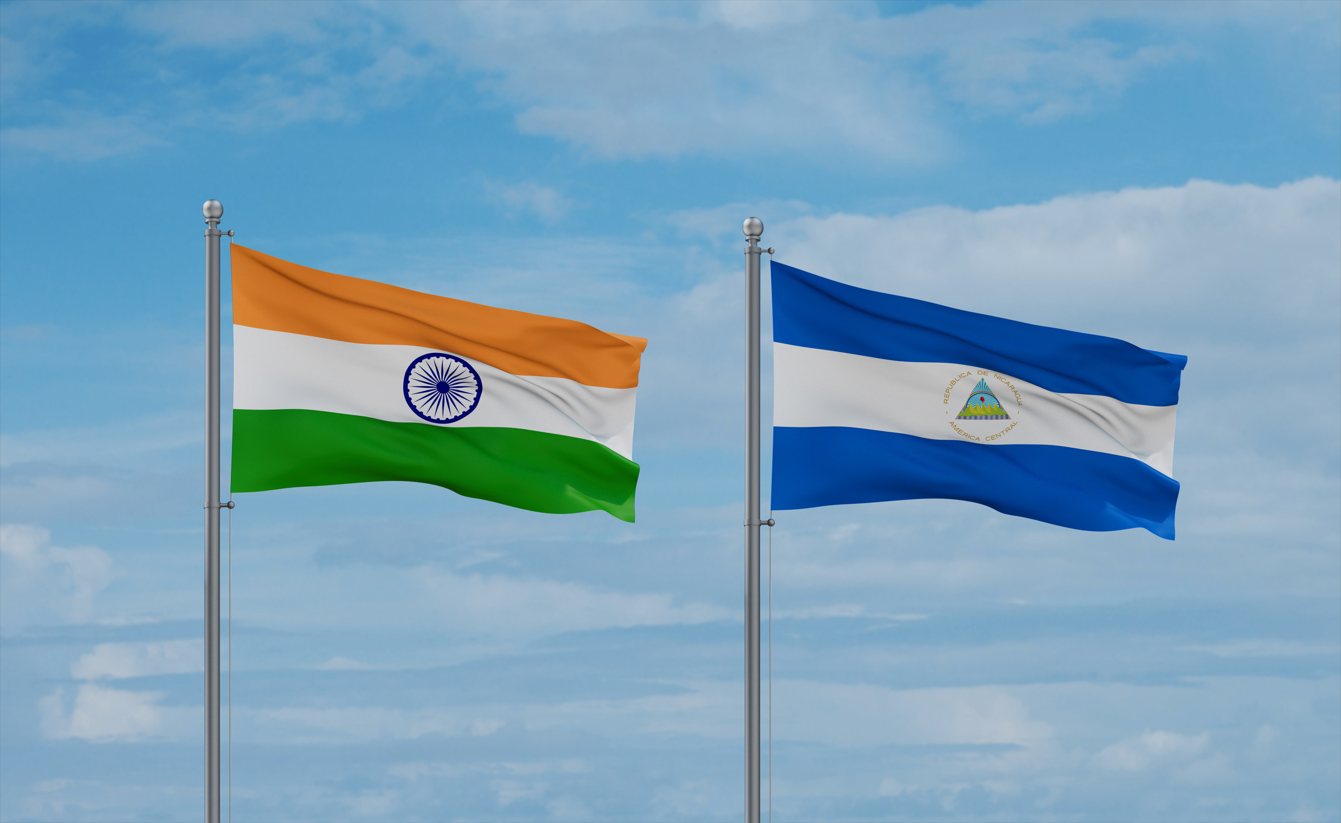 Nicaragua und Indien Flaggen wehen gemeinsam am blauen, wolkigen Himmel – Beziehung zwischen zwei Ländern