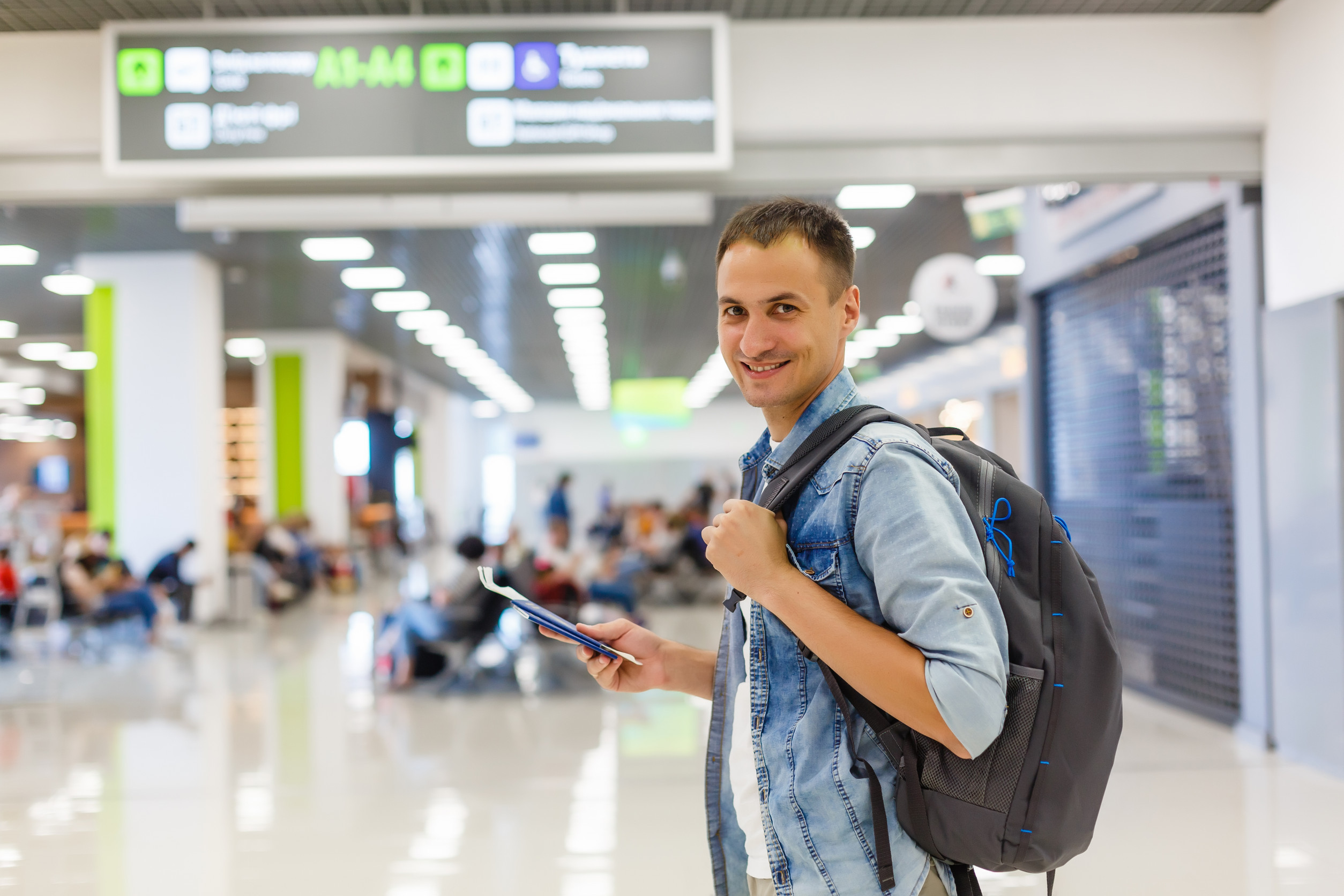 Porträt eines glücklichen männlichen Reisenden, der mit Rucksack läuft